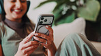 Woman, hands and relax in home with mobile, social media and latest celebrity gossip in online news. Person, phone and smile in living room for funny article, headphones and check text notification