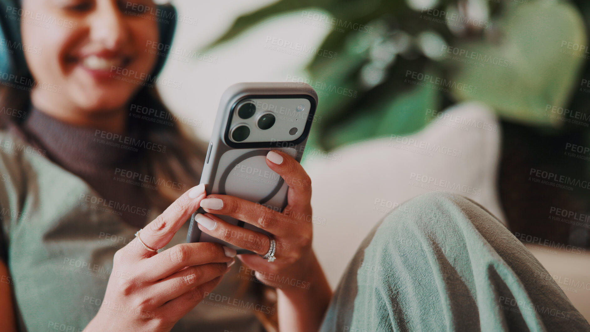 Buy stock photo Woman, hands and relax in home with mobile, social media and latest celebrity gossip in online news. Person, phone and smile in living room for funny article, headphones and check text notification