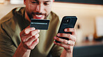 Smile, man and credit card at house with phone, payment and secure purchase for black friday sale. Happy, male person and transaction in lounge with mobile, fintech and retail bargain for ecommerce