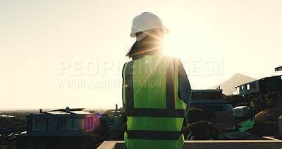 Buy stock photo Back, engineer and woman at construction site with rooftop, thinking and planning for infrastructure. Flare, space and person outdoor in suburb with PPE, reflection and supervisor for engineering.