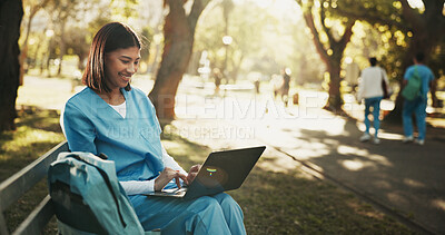 Buy stock photo Laptop, medical student and woman at park for education, research feedback or course module report. Computer, happy person and trainee nurse on bench outdoor, learning or typing healthcare review