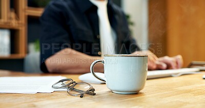 Buy stock photo Coffee, desk and glasses in office with employee typing on keyboard for report or research. Cup, documents and eyewear of person at table in workplace for planning, review or strategy on computer