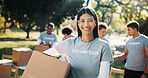 Portrait, volunteer and happy woman with box in park for outdoor donation, charity or outreach. Female person, activist or NGO with smile or package for community service, mission or contribution
