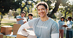 Volunteer, portrait and man with box outdoor for outreach program, community service and welfare. Happy, park and person with package for food drive, donation and charity event for ngo campaign