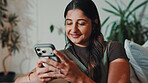 Happy, woman and typing in living room with phone, search trends or download app for online shopping. Person, relax and internet in home with tech, social media and browsing website for ecommerce.