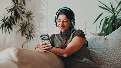 Buy stock photo Woman, happy and headphones or phone on home sofa for streaming music, podcast or subscription. Smile, audio playlist and female person relax on couch with mobile app, technology and sound online