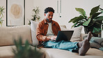 Man, typing and remote work in home with laptop, research and download AI to track carbon footprint. Freelance environmentalist, person and online on couch with computer, innovation or sustainability