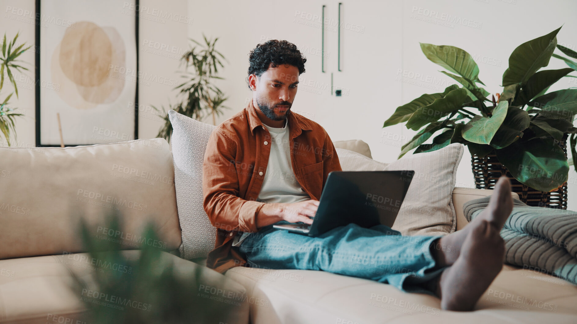 Buy stock photo Man, typing and remote work in home with laptop, research and download AI to track carbon footprint. Freelance environmentalist, person and online on couch with computer, innovation or sustainability