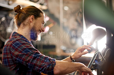 Buy stock photo Happy, repairs and man with fixing bicycle in garage for maintenance on wheels, chain or frame. Small business, service and male mechanic with tightening mechanical part on bike at workshop.