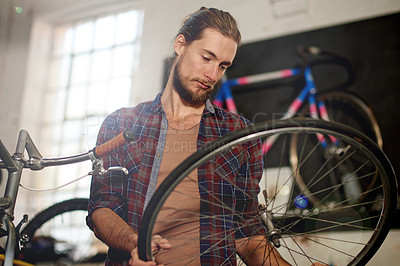 Buy stock photo Man, repair or wheel inspection with bicycle for maintenance or fix in workshop or garage. Male person, bike mechanic or cycle technician with part for air pressure, mend or replacement service