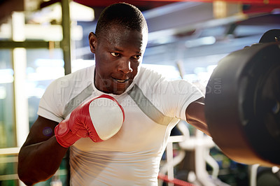 Buy stock photo Boxing, man and fight with pad at gym for punch training, sweating and intense challenge. Black person, fitness and champion boxer in health club for conditioning, combat sports or muscular endurance