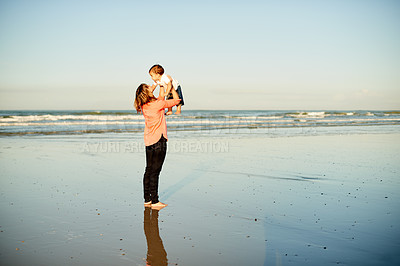 Buy stock photo Beach, bonding and mother holding child for playing, care and connection together by ocean. Love, happy and mom lifting boy kid in air for fun by sea water on summer vacation, getaway or weekend trip