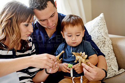 Buy stock photo Toys, playing and parents with toddler on sofa in home for bonding, connection or family time. Love, care and boy child with mother and father for sensory development in living room together at house