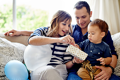Buy stock photo Parents, child and present for birthday in house for milestone, celebration and love together in living room. Gift, open box and mother with toddler, father and care at party or event in family home