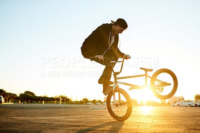 Buy stock photo Sunset, adventure and man on bicycle outdoor with tricks, fun or skills for activity with cycling. Adrenaline, space and person on bike training for competition, challenge or race in urban town.
