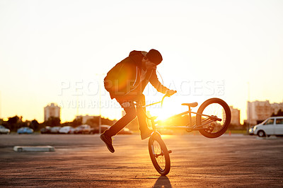 Buy stock photo City, skill and sunset with man on bicycle for adrenaline, exercise or extreme sports outdoor. BMX, flare and training with bike rider in parking lot of urban town for action, balance or practice