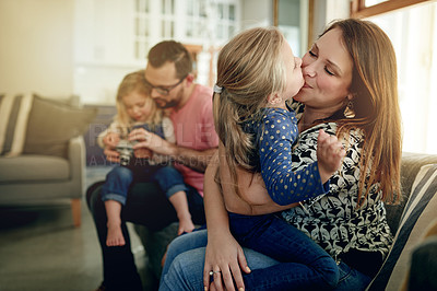 Buy stock photo Kiss, family time and parents with kids in living room for bonding, play together and cozy weekend morning. Love, caring man and woman with children in home for support, happiness and relationship.