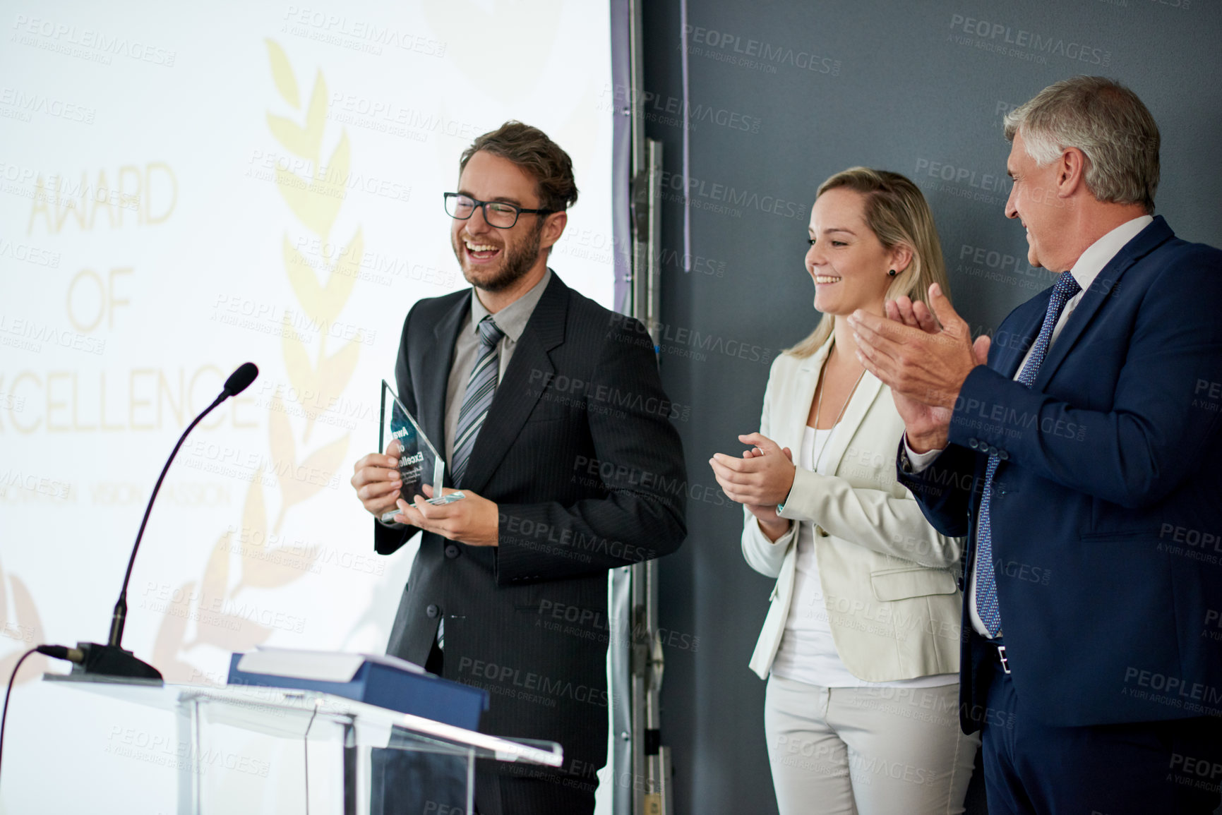 Buy stock photo Happy, businessman or applause with award on podium for congratulations or winning in workshop. Excited group, employee or team clapping with trophy for reward nomination or promotion in ceremony