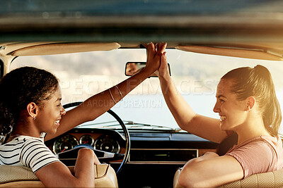 Buy stock photo High five, road trip and women in car for travel, holiday or vacation on outdoor adventure. Smile, explore or friends with celebration, ocean view or bonding for weekend getaway, scenery or journey