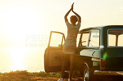 Buy stock photo Shot of a happy young woman enjoying a road trip