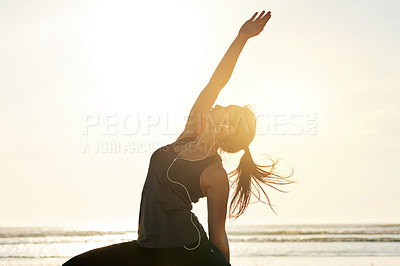 Buy stock photo Girl, earphones and beach yoga at sunset for balance, calm and peaceful mindset in zen space. Triangle pose, music and wellness frequency tone for mental clarity, stretching and body movement by sea