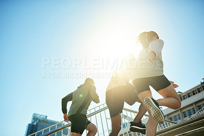 Buy stock photo Fitness, group and running in city for health, body wellness or friends training in low angle. Team, cardio and people exercise outdoor on stairs for workout, sport or race with energy on sky space