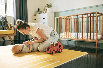 Buy stock photo Love, bonding or mother playing with baby in nursery, having fun or enjoy relax quality time together in home. Happy family, growth or newborn child care of youth kid and mom tickling infant on floor