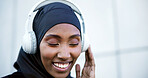 Outdoor, fitness and muslim woman with music, listen to radio or streaming song with happiness. Hijab, active and black person with headphones, podcast and smile on audio break with space in city