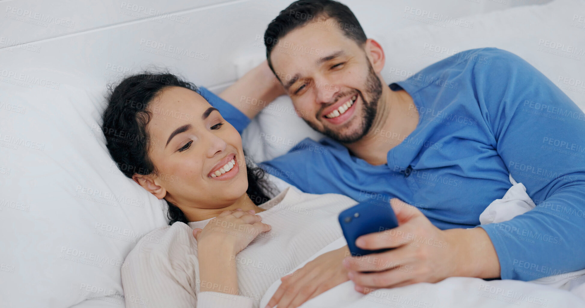 Buy stock photo Happy, bed and couple in morning with phone for social media, online videos and wake up in home. Bedroom, marriage and man with woman on cellphone for internet, website and talking on weekend