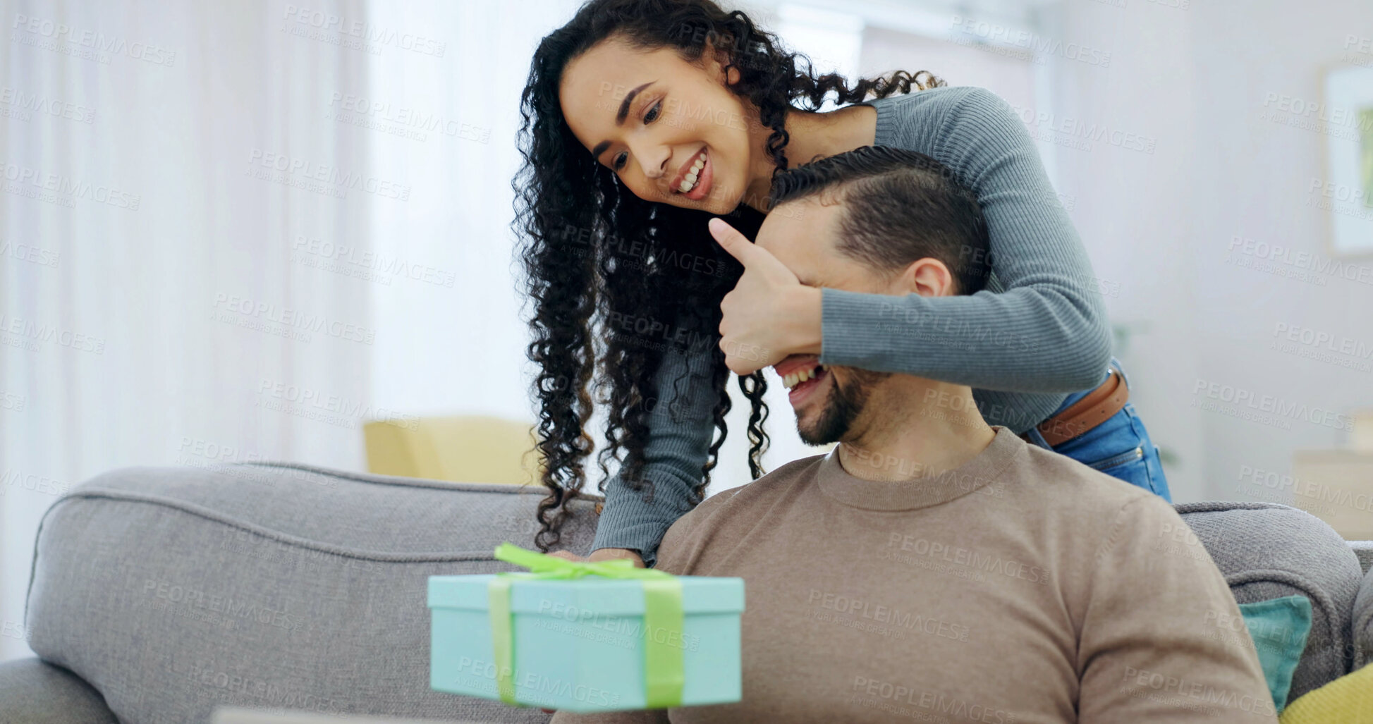 Buy stock photo Couple, sofa and surprise gift with cover for anniversary celebration, smile or partner appreciation. Eyes closed, giving present and happy people in home for care, relationship connection and love