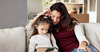 Buy stock photo Mom, child and mobile game in home with phone, bonding together and learn how to play for knowledge. Woman, daughter and supervision on sofa with tech, parent care and online gaming for education.