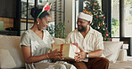 Christmas, gift and black couple on sofa in home with surprise for festive celebration or holiday. Happy, man and woman with box, smile or present for December, Santa weekend or package in house