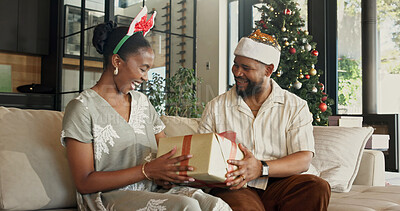 Buy stock photo Christmas, gift and black couple on sofa in home with surprise for festive celebration or holiday. Happy, man and woman with box, smile or present for December, Santa weekend or package in house