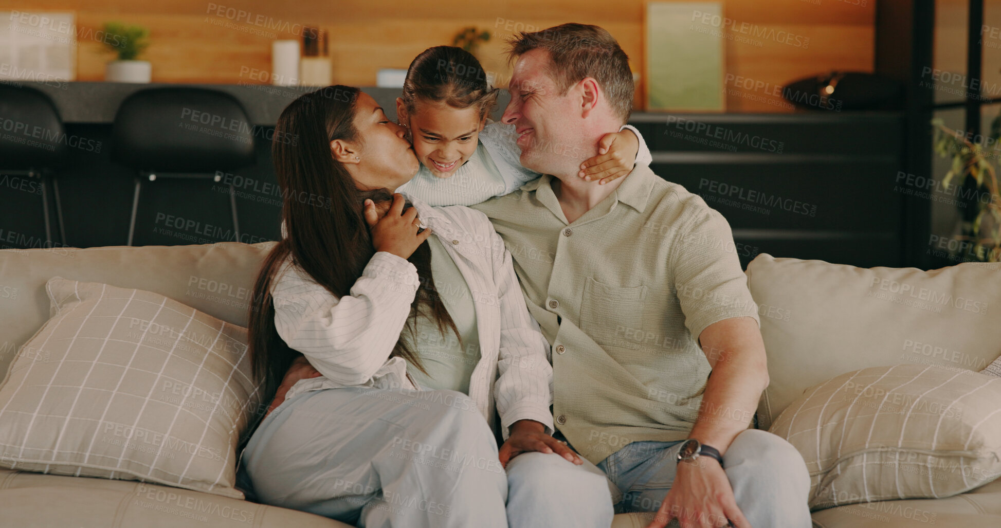 Buy stock photo Happy, kiss and parents with child on sofa for bonding, loving relationship and connection. Hug, family home and girl with mom, dad and affection for care, moment and trust for embrace on weekend