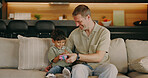 Family, dad and child with toy in lounge, fun and bonding with boy on break and laughing together. Cognitive development, home and happy man with kid in living room, connection or playing with son