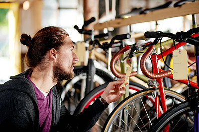 Buy stock photo Customer, shop and man with bicycle price in retail store for present, gift and upgrade. Choice, check or person in warehouse with label for cycling options, inspection or transportation information