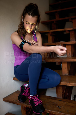 Buy stock photo Earphones, fitness and girl in home getting ready for running, workout or training for marathon. Arm band, teenager and female athlete on stairs preparing for cardio exercise with music in apartment.