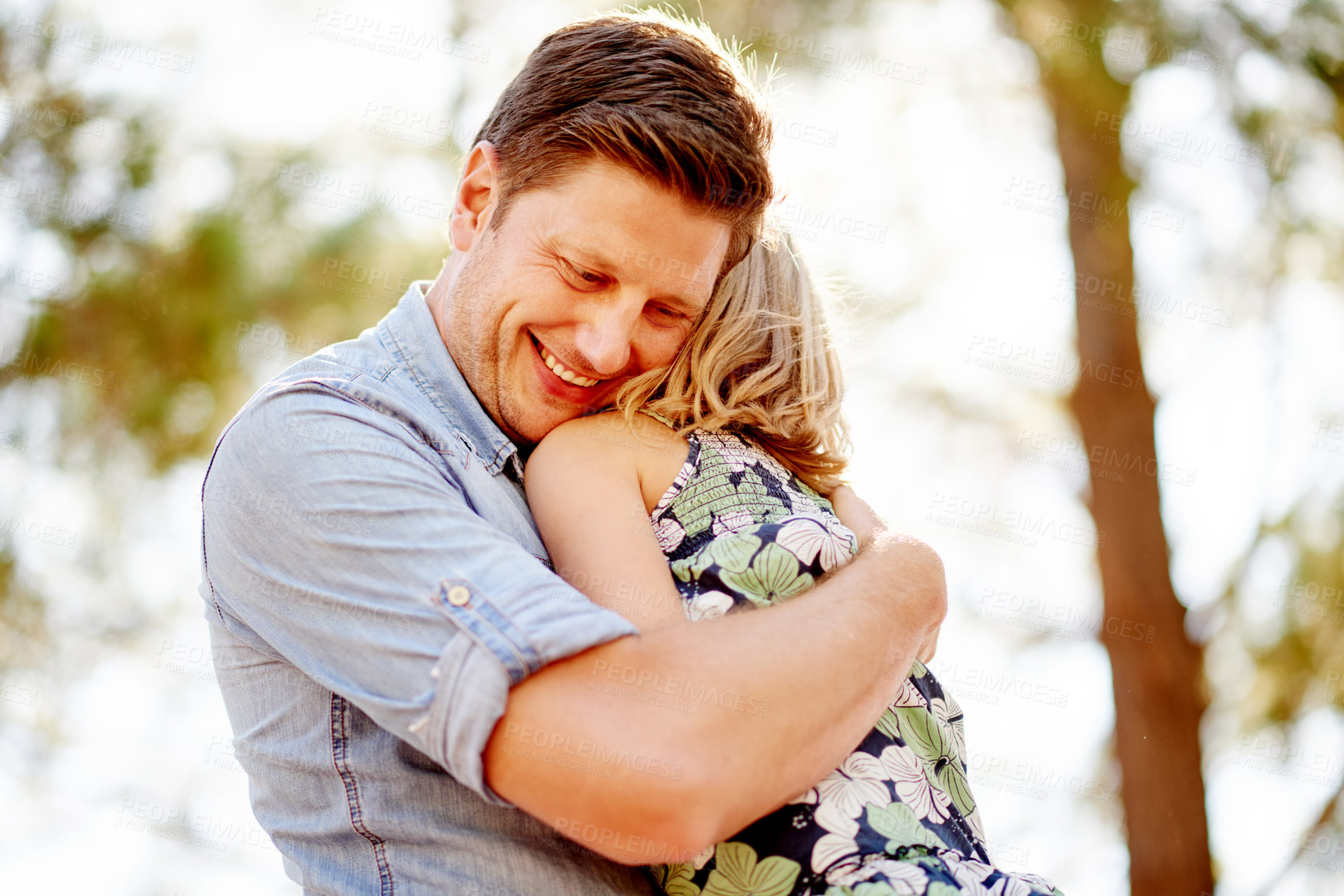 Buy stock photo Dad, smile and hug kid for love, care or bonding together for connection on holiday in nature. Father, girl and embrace child at park for support, trust or safety with happy parent on family vacation