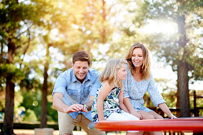 Buy stock photo Happy, parents and kid on carousel at playground for holiday fun, play games and bonding together. Smile, family or child on merry go round for spinning ride, activity and balance support on vacation