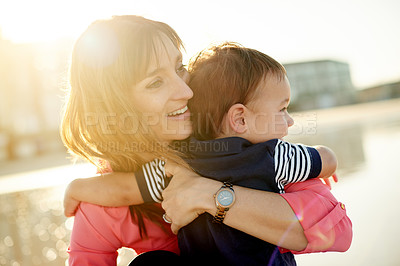 Buy stock photo Mother, toddler and flare at beach with hug, cuddle or love for bonding on holiday. Happy woman, boy child with embrace or holding kid outdoor, sunshine and adventure with travel view in Australia