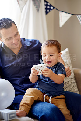 Buy stock photo Birthday, celebration or present with father and son on sofa in living room of home for milestone. Excited, gift or happy with boy child and single parent man in apartment together for bonding or fun