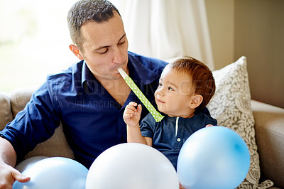 Buy stock photo Father, son and smile with party whistle for birthday, childhood or bonding on sofa in home. Dad, child and horn for celebration, love and fun in living room of house for event together with balloons