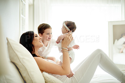 Buy stock photo Happy, mom and bonding with children, bedroom and smile with son, love and family with baby in home. Single parent, rest and care for infant, boy and affection for sister with woman, relax or break