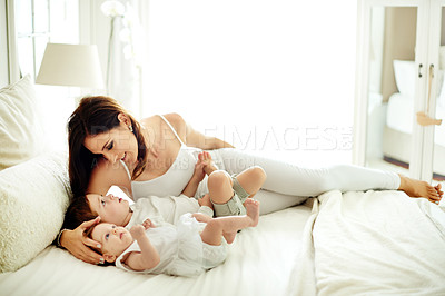 Buy stock photo Mom, relax and lying with baby in bed for love, comfort or gentle parenting with siblings in home. Happy mother, kid or youth with smile for childhood development, growth or bonding together in house