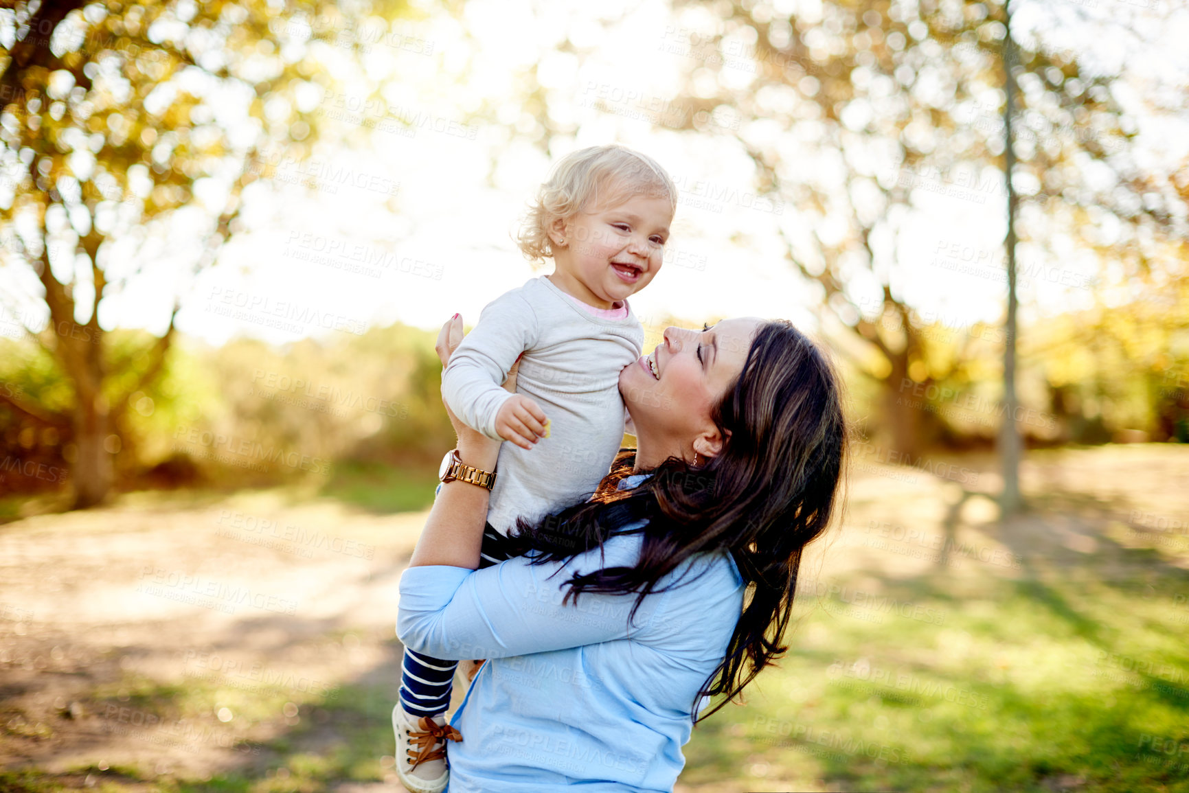 Buy stock photo Happy mom, baby and hug with lift in nature for love, embrace or outdoor summer fun together. Mother, child or kid with parent, daughter or smile for comfort, weekend wellness or childhood in park