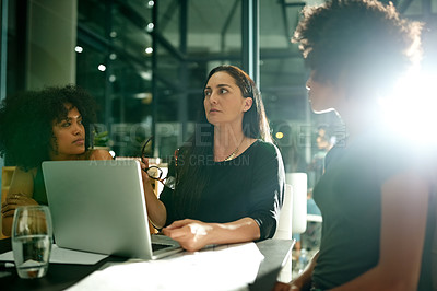 Buy stock photo Women, meeting and laptop at startup, night and discussion with review, insight and project at media company. People, editor and team with documents, talk or feedback with computer at creative agency
