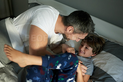 Buy stock photo Happy, playful or tickle with father and son in bedroom of home together for bonding or fun. Laughing, love or morning with boy child and single parent man on bed in apartment for wake up from above