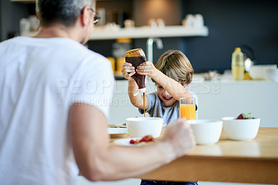 Buy stock photo Breakfast, father and child in kitchen with syrup, meal prep and excited for bonding. Happiness, boy and man in home with food, snack and hungry in morning for growth and development in childhood