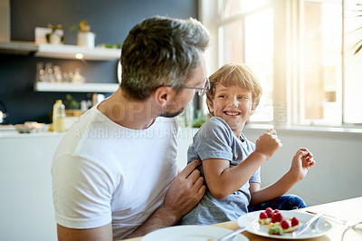 Buy stock photo Breakfast, happy and father with child in kitchen in home with bonding, laughing and playing. Smile, tickling and dad with boy kid for eating healthy morning meal together with connection in house.