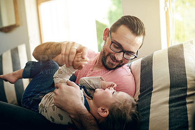 Buy stock photo Smile, father and play with child on sofa for love, affection and funny games for weekend break. Happy, man and embracing with toddler laughing for fun together, family bonding and support at house